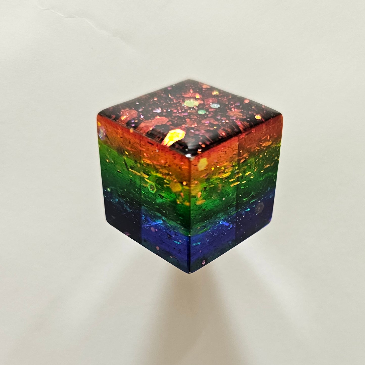 Rainbow-colored cube with a gradient from red to purple on a white background