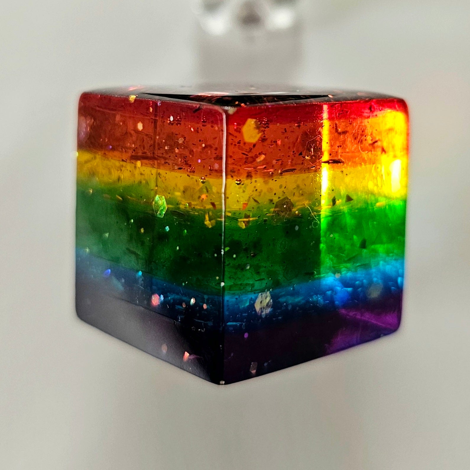 Rainbow-colored cube with a gradient from red to purple on a white background
